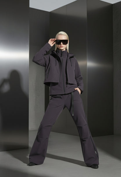 Person wearing a dark outfit with sunglasses in a minimalistic setting